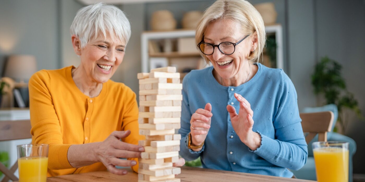 2 seniors play a leisurely board game together and have a joyful and fulfilling experience.