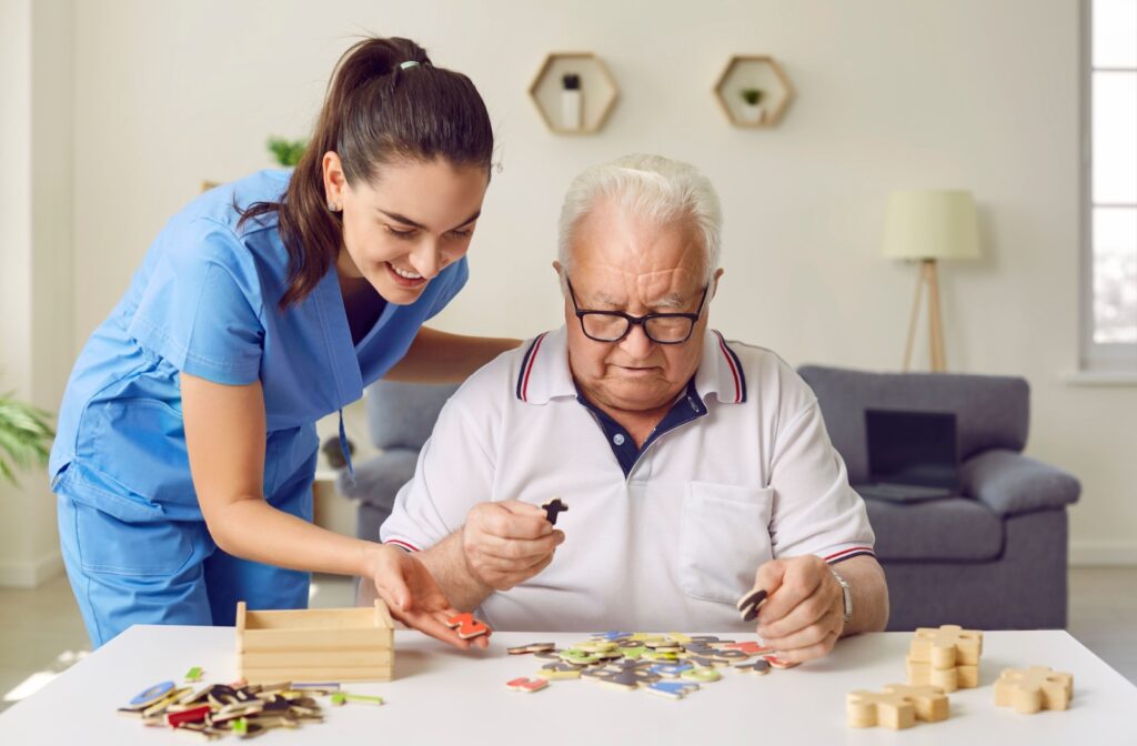 Nurse assisting a senior with a puzzle in an assisted living community.