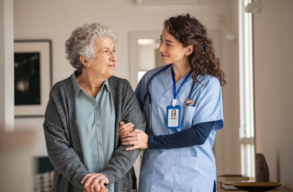 A senior woman being taken care of while walking by a caregiving staff member at norbella senior living.