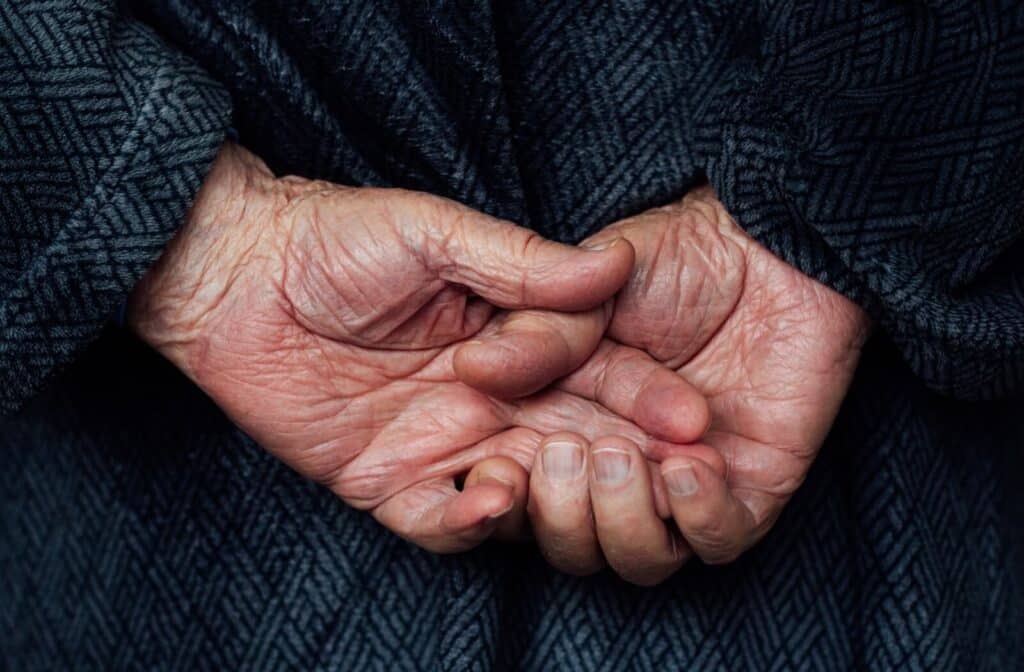 An older adult laces their hands behind their back to test their cognitive abilities